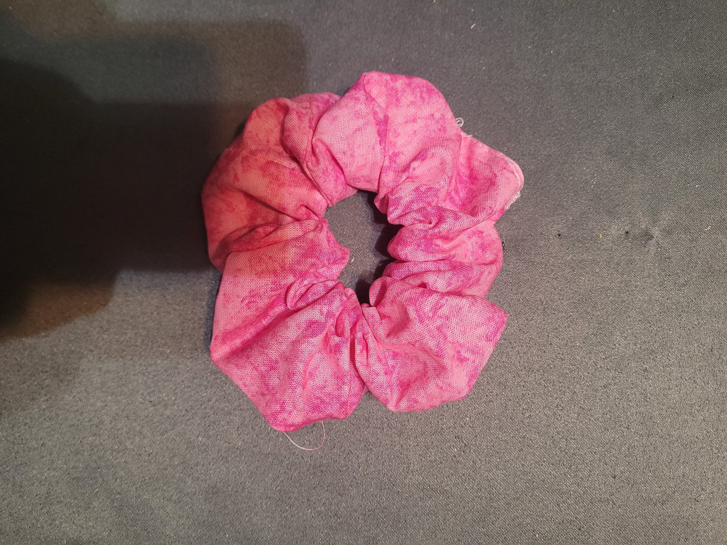 Scrunchie made of a very pink tie dyed fabric.