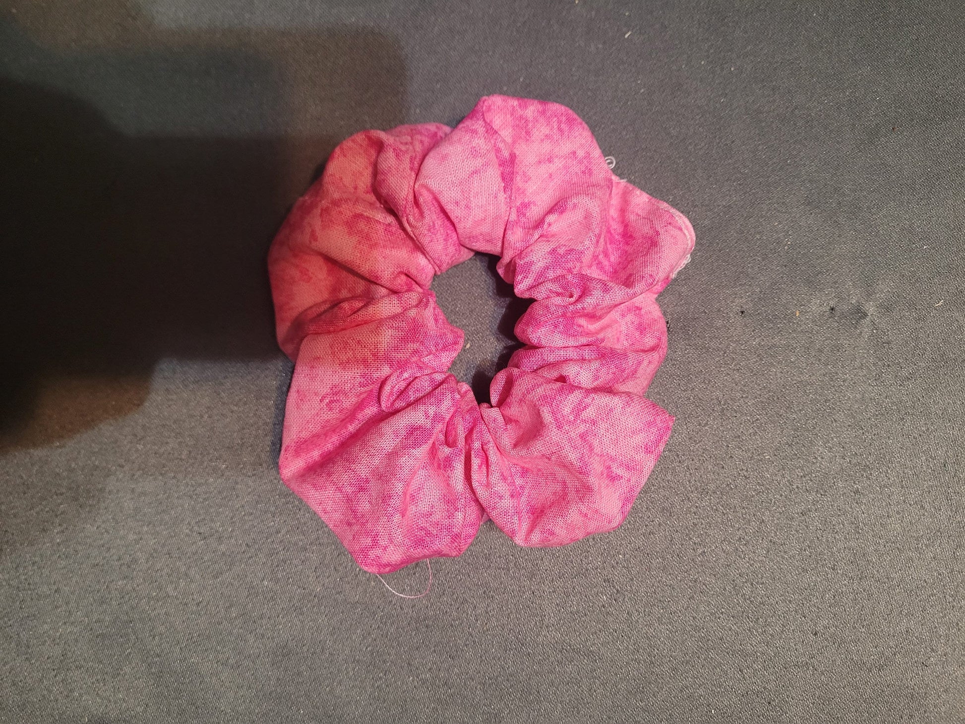 Scrunchie made of a very pink tie dyed fabric.