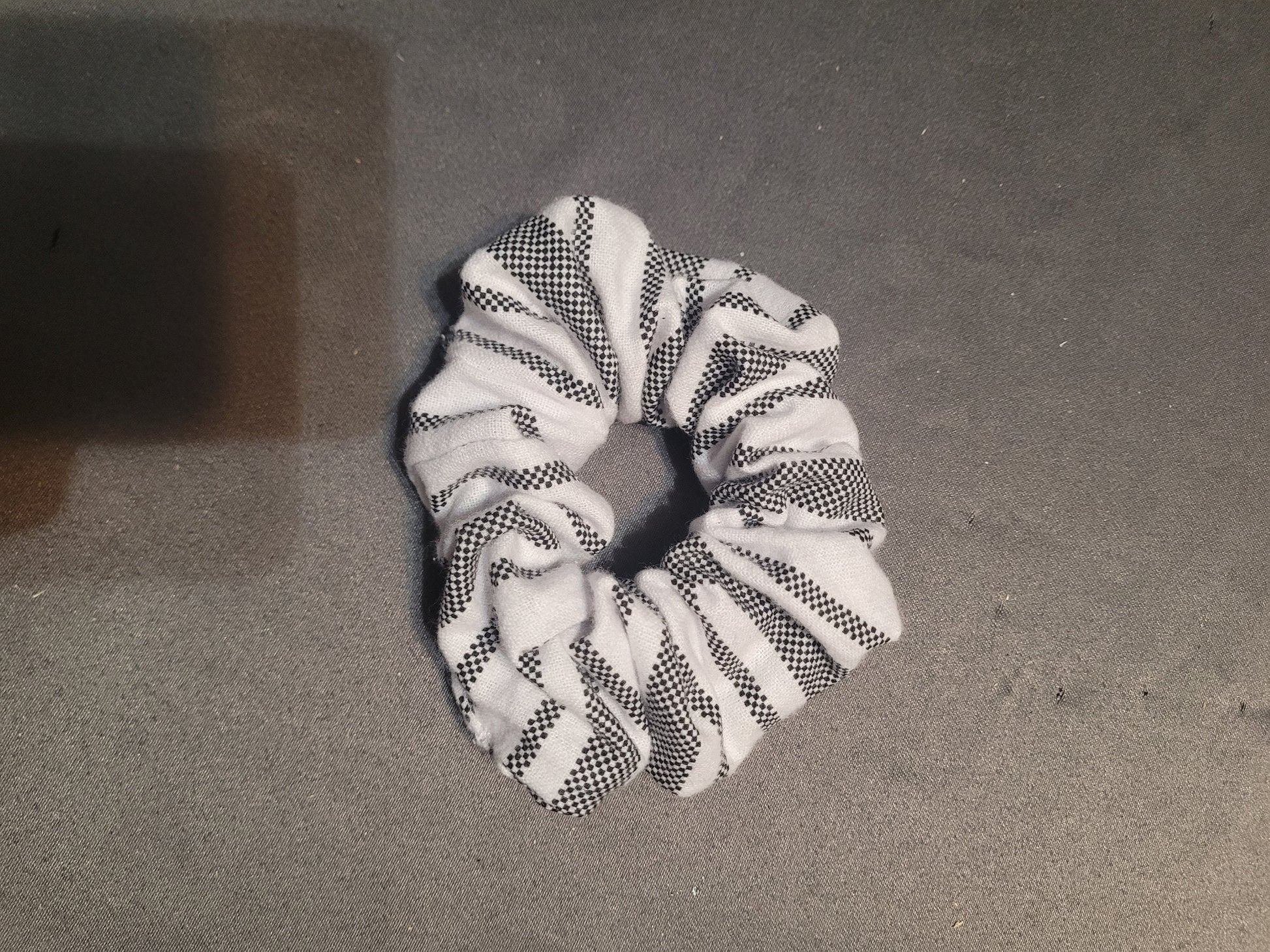 Scrunchie that is white with dotted black stripes