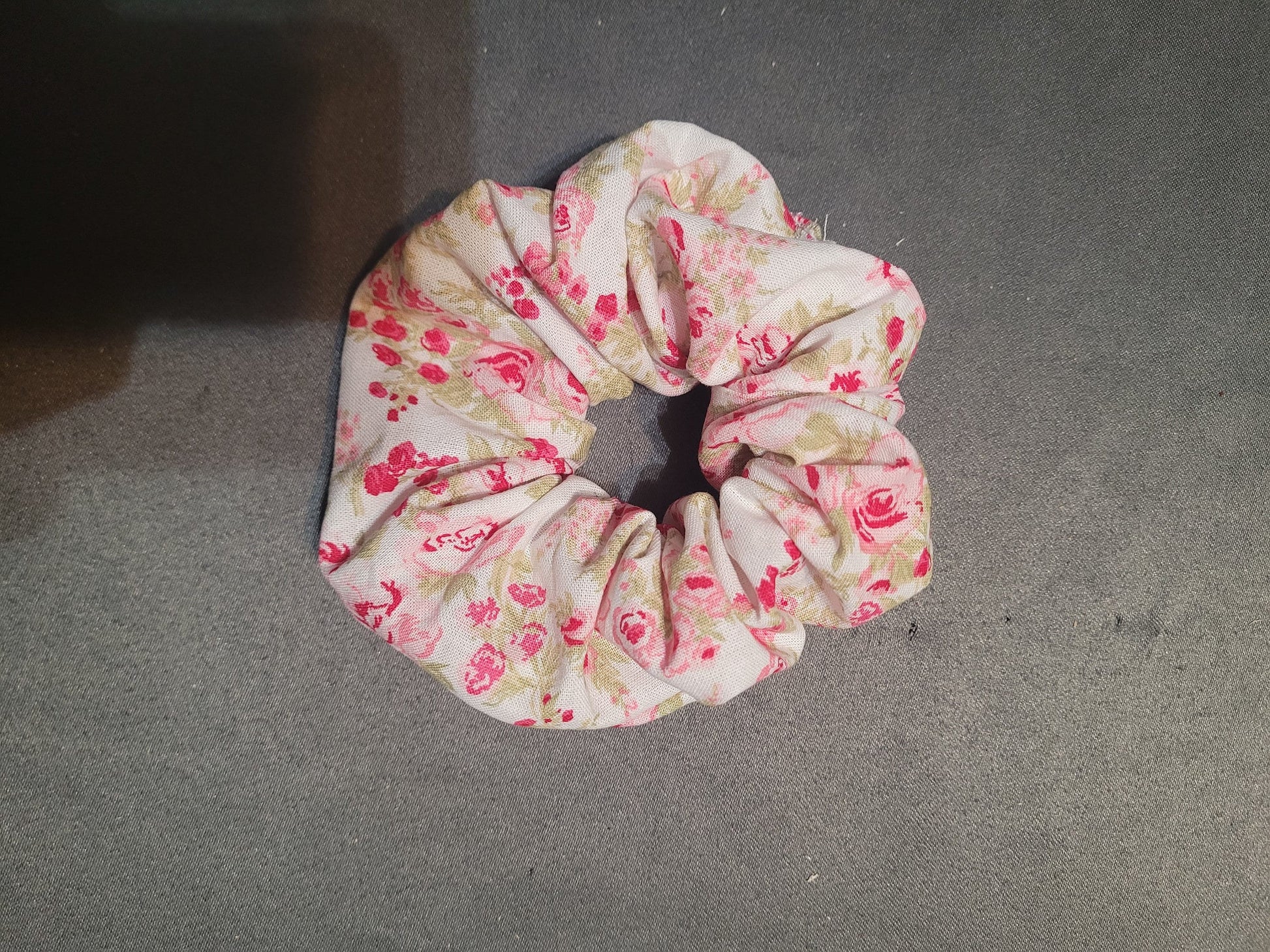 Scrunchie with fabric that is pink roses on a white background